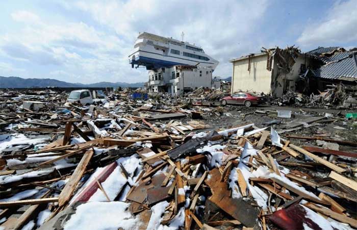 A boat swept onto the roof of a two-story house in Iwate by the tsunami.