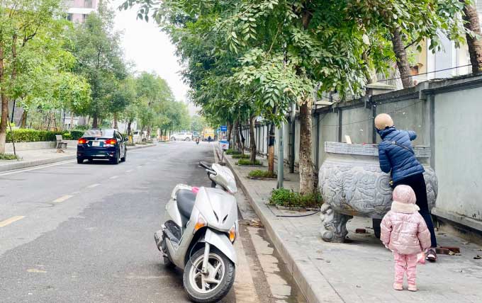 A resident burning paper offerings during the Kitchen Gods festival in a urban area in Bac Tu Liem District.