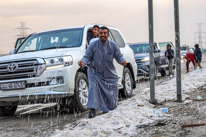 Kuwait residents playing with hail on a road in Umm al-Haiman.