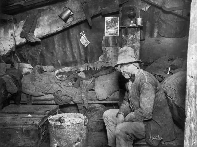 A man smoking a pipe in the basement of an apartment building