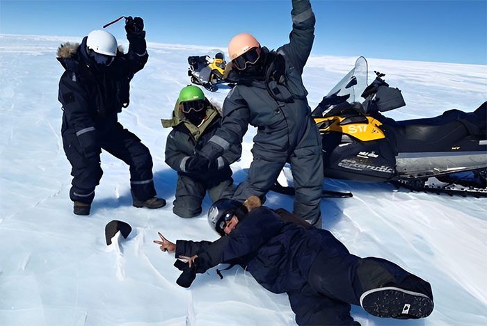 The expedition team poses beside the newly discovered giant meteorite.