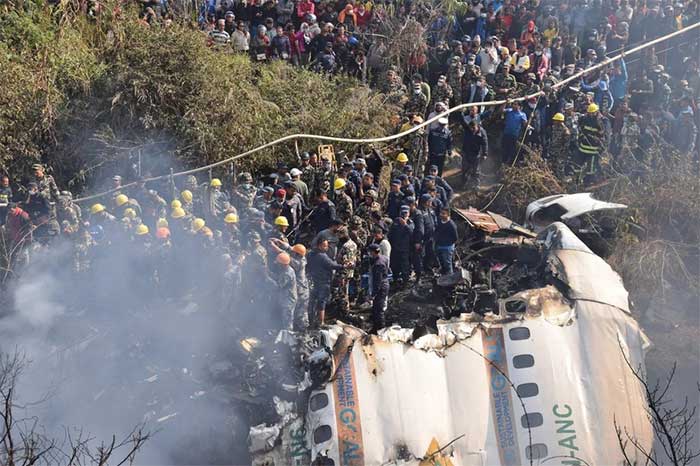 Nepalese citizens and rescue teams gather near the crash site in Pokhara