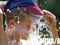 A boy cooling off under a water faucet in Berlin on July 19
