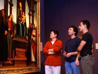 Experts examining the painting "The Virgin and Four Saints" by Perugino