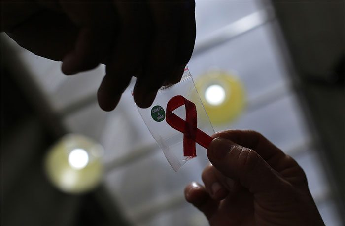 A nurse hands out red ribbons to mark World AIDS Day