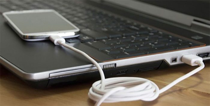 Placing your phone next to the laptop's cooling fan can cause overheating and damage.