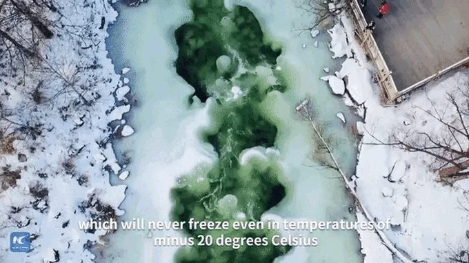 The landscape is covered in a thick layer of snow and ice, yet the water continues to flow