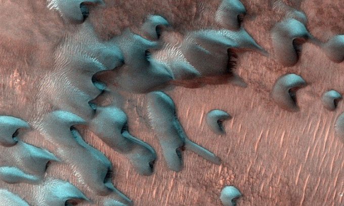 Frost covers the colder side facing north of a sand dune on Mars.