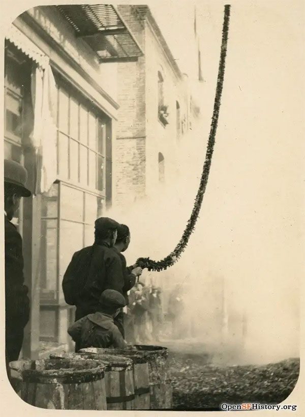 A man lighting a firecracker, 1905.