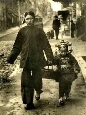 A woman and baby carrying New Year gifts, 1912.