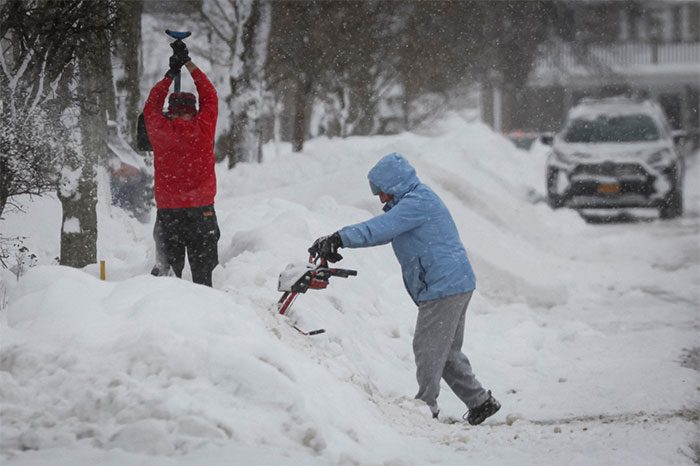 Some residents of Amherst (Buffalo) shovel snow from in front of their homes.