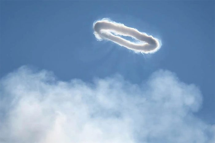 Circular smoke rings appear above the crater of a volcano.