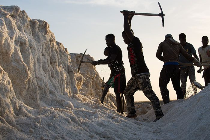 Young men carving hard salt on Diouf's land in Fatick.