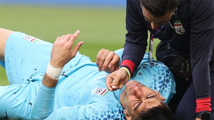Ali Beiranvand lying on the field after colliding with a teammate.