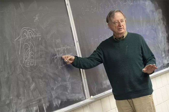 Dennis Sullivan presenting on a blackboard at Stony Brook University in New York.