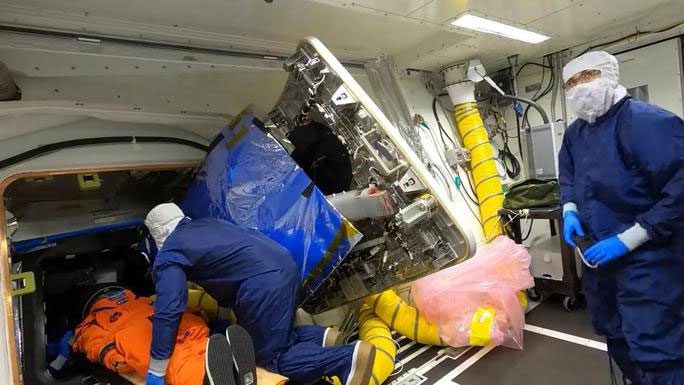 NASA scientists attaching Moonikin Campus to the spacecraft