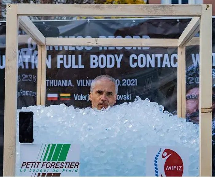 Valerjan Romanovski immersing himself in a large glass box filled with ice.