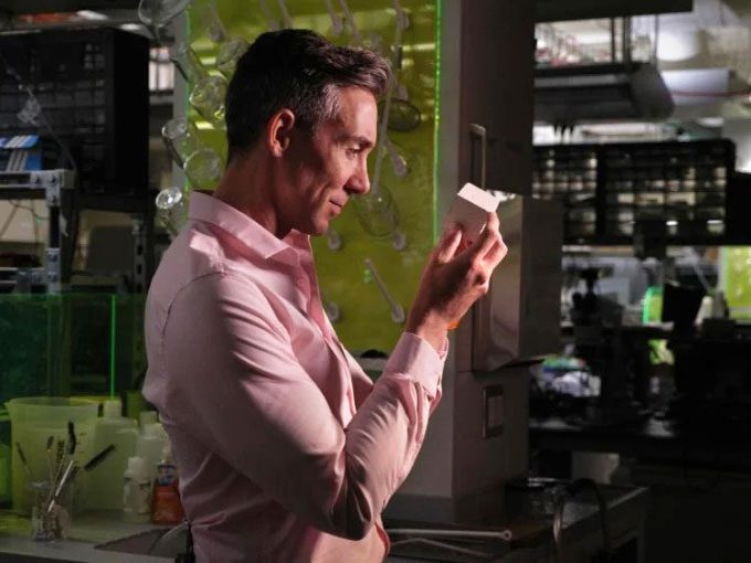 Wil Srubar holding a sample block of concrete developed from microalgae.