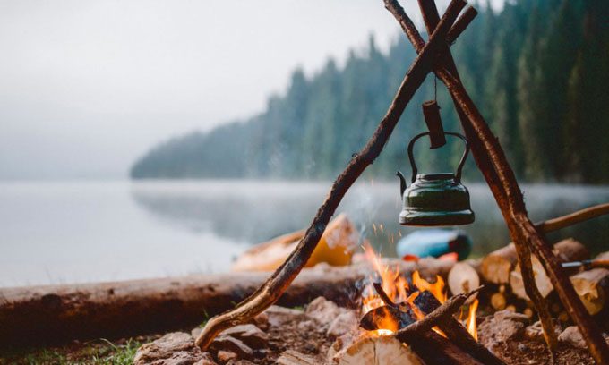 The metal pot does not catch fire like the wooden logs underneath.