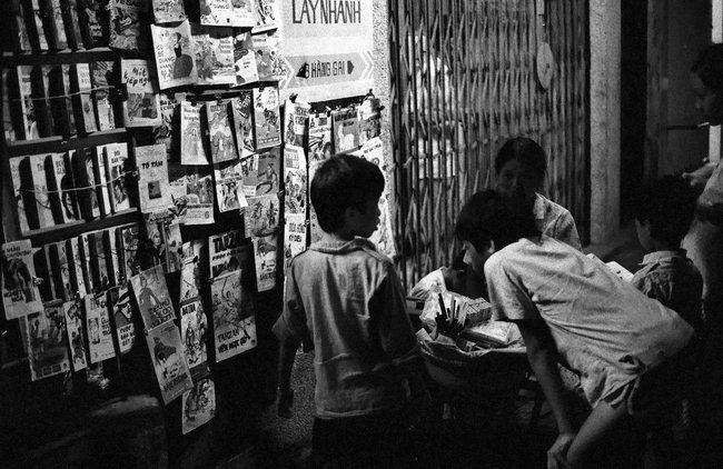 Old newspaper shop on Hang Gai Street at night.