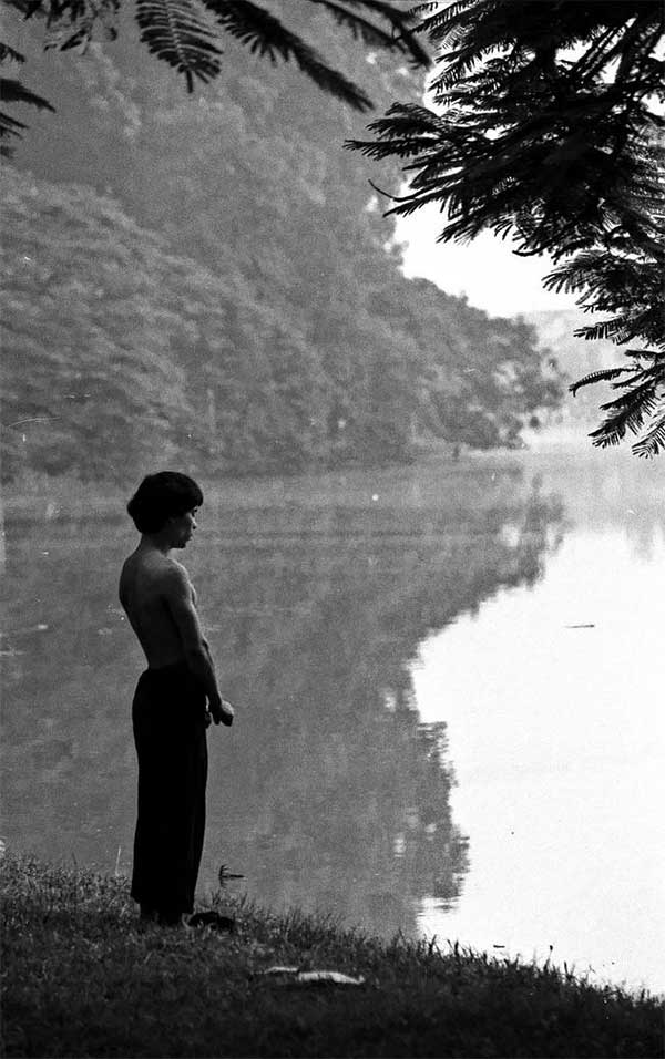 A man practicing Qigong by the lake in the early morning.