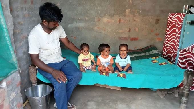 The three children with small bodies often need their parents to carry them due to mobility difficulties.