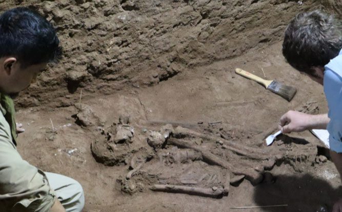 Archaeologists examining the unusual skeleton