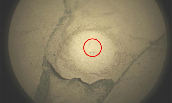 Three small dots in the shape of an L created by the Perseverance rover using a laser on a Martian rock on June 17.