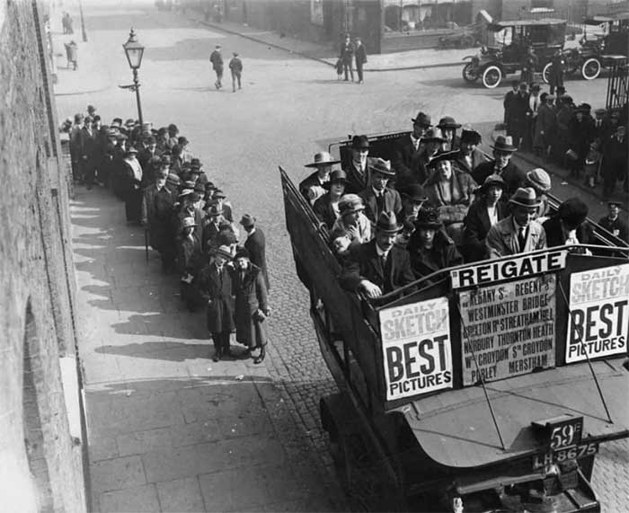 Passengers lining up to board an open-top bus in London during the holiday season in 1921.