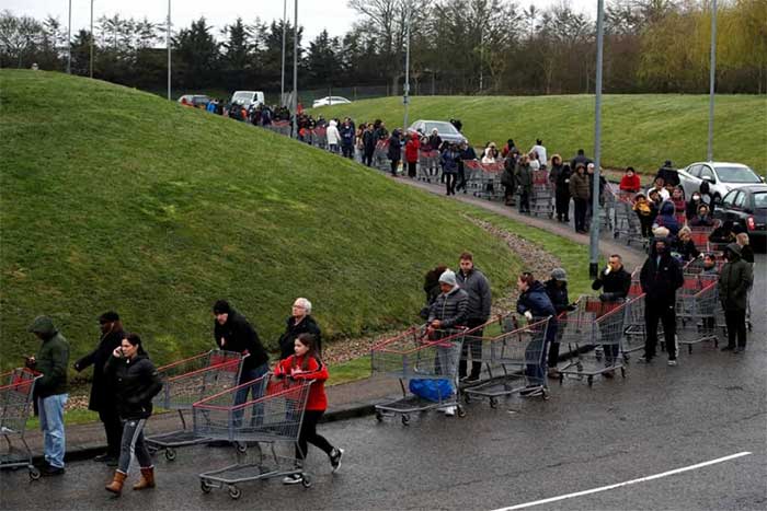 People lining up outside a store in Watford, England