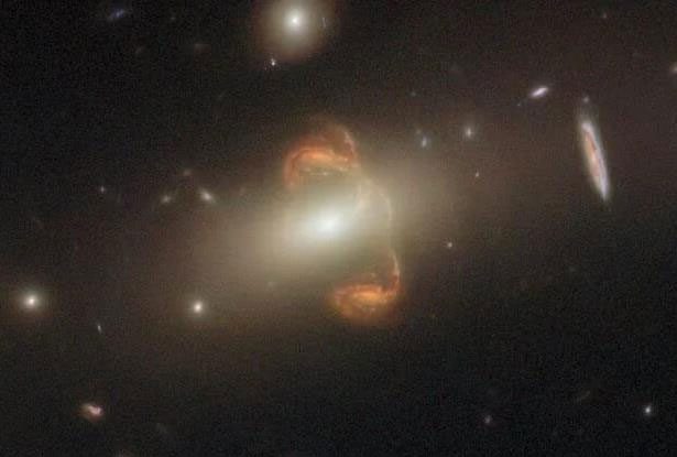 Unique image featuring an orange galaxy and its symmetrical ghost