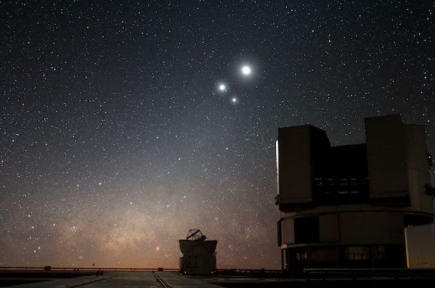 The Moon shines brightly in the sky over Chile, with Venus and Jupiter nearby