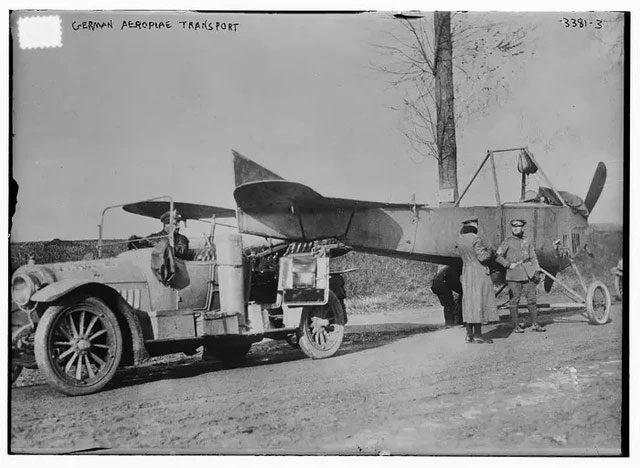This image shows a German car towing an airplane during World War I.