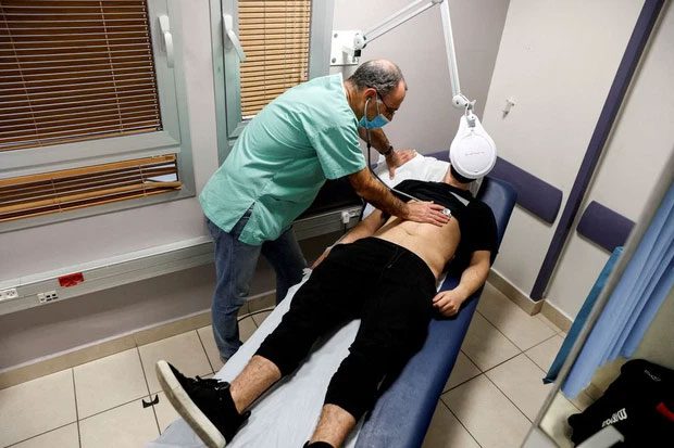 A doctor examines a patient suffering from post-Covid-19 syndrome in Tel Aviv, Israel.