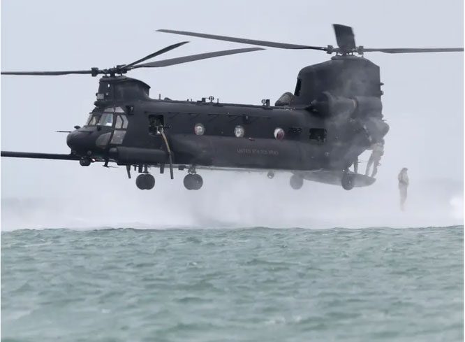 A student jumps out of an MH-47 helicopter during CDQC training on February 21, 2020.