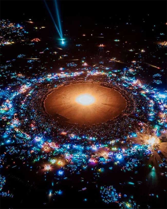 A photo of the Burning Man festival from above that looks like a galaxy in the universe.