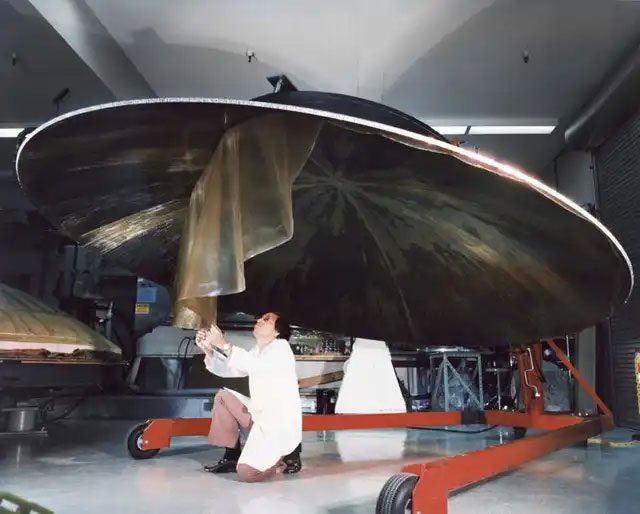 An engineer working on a large dish antenna of Voyager on July 9, 1976.