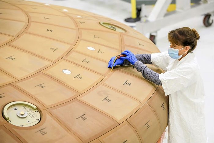 Engineers working with over 180 heat shields of Orion at Kennedy Space Center.