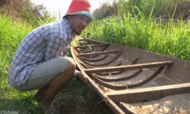 The man flips the boat over and is surprised by the discovery underneath