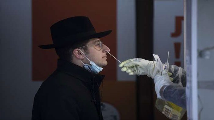 An Israeli healthcare worker takes a Covid-19 test sample from a Jewish student