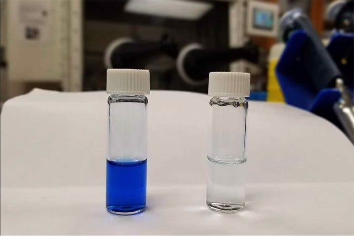 A jar of dye-contaminated water and a jar of polymer used to remove the dye.