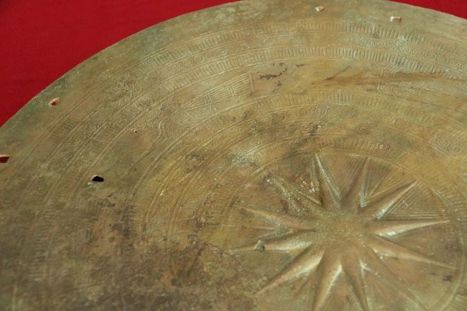 Image of a 12-pointed star and 6 birds flying counterclockwise on the drum's surface.