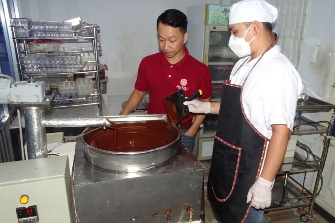 Author Nguyen Hong Huy (left) with the chocolate tempering machine.
