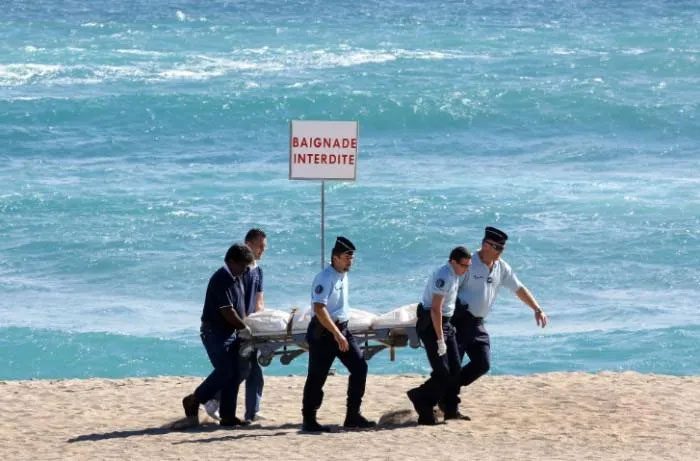 Authorities carry the body of a tourist who died after a shark attack