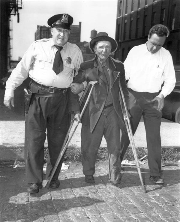 Chicago police escorting a person with a leg disability to the station in 1954.