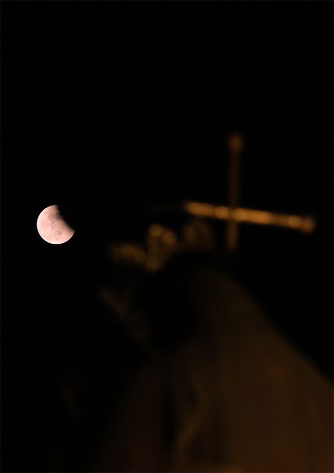 The Moon above the statue in front of the St. Joseph's Cathedral.