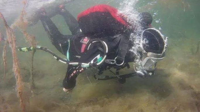 A scientist diving to the site of the ghost ship