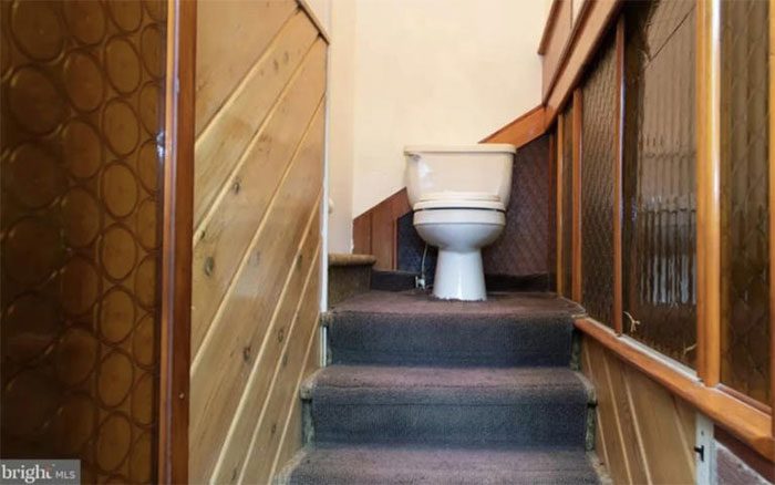 The quirky house places a toilet in the middle of the staircase.