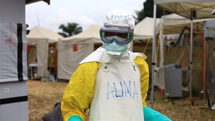 Healthcare workers in protective gear working at an Ebola treatment center in Beni