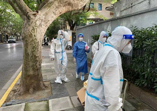 Health worker in protective gear walking on the street after a severe Covid-19 outbreak in Shanghai